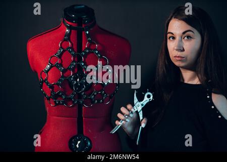 Tanner woman portrait with leather harness on mannequin Stock Photo