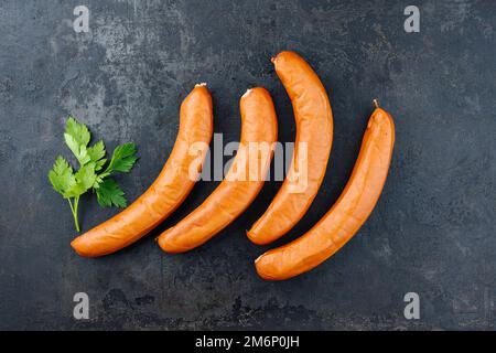 Traditional raw German bockwurst offered as top view on rustic black board with copy space Stock Photo