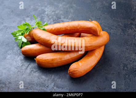 Traditional raw German bockwurst offered as close-up on rustic black background Stock Photo