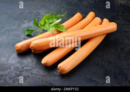 Traditional raw German bockwurst offered as close-up on rustic black background Stock Photo