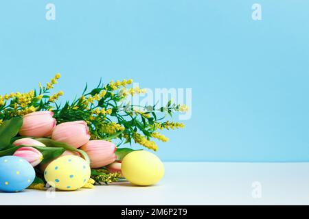 Spring composition. Blooming branch flowers tulips easter eggs on the table. Stock Photo