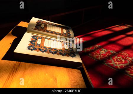 Islamic background photo. First pages of Quran on the lectern in the mosque illuminated by sunlight. Ramadan or kandil or laylat al-qadr or kadir gece Stock Photo