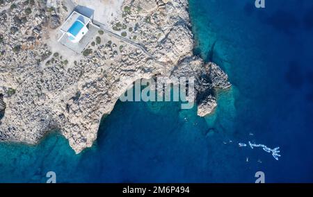 Drone aerial photograph of Cape Greco peninsula with Agioi Anargyroi church on the rocks. Turquoise ocean water Stock Photo