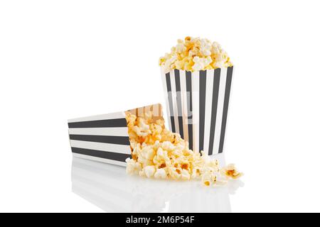 Two black white striped carton buckets with tasty cheese popcorn, isolated on white background. Box with scattering of popcorn grains. Movies, cinema Stock Photo