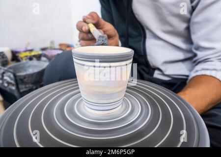Craftsman painting and decorating ceramic products in pottery factory in Fez, Morocco, North Africa Stock Photo