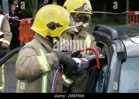 Dreghorn, Ayrshire, Scotland, UK : Firefighters from Scottish Fire & Rescue demonstrate taking a car roof off in front of secondary school pupils Stock Photo