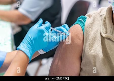 Woman with face mask getting vaccinated, coronavirus concept. Stock Photo