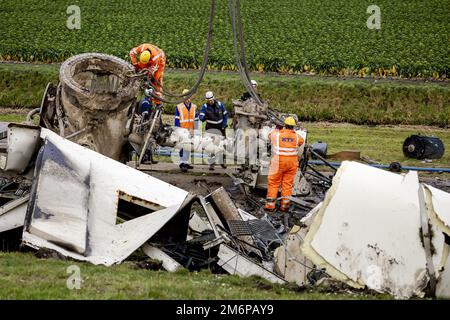ZEEWOLDE - Work with a crane on the debris of the demolished windmill in Zeewolde. The wind turbine was an older model and stopped after an error message. The wind was blowing hard, but it is not yet clear whether the windmill has broken as a result. ANP ROBIN VAN LONKHUIJSEN netherlands out - belgium out Stock Photo