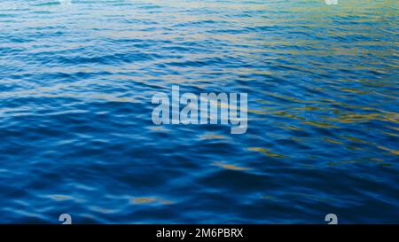 Waveless, calm sea at sunset. Pale sun rays reflecting off the sea. Stock Photo