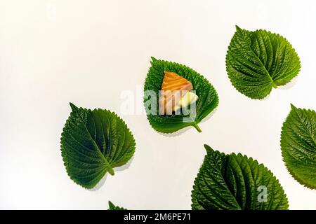 Sliced salmon and garlic on the fresh sesame leaves, arranged perilla leaves Stock Photo