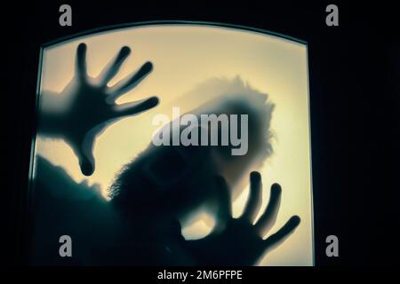 Scary picture of hands behind glass, horror ghost woman behind door, Halloween  concept Stock Photo