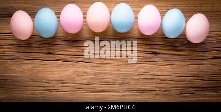 Multicolored eggs on a wooden texture. Easter background Stock Photo