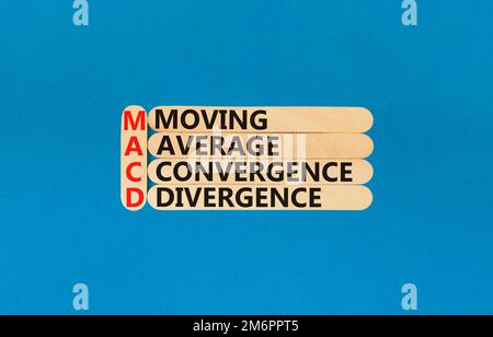 MACD symbol. Concept words MACD moving average convergence divergence on wooden stick on beautiful blue background. Business MACD moving average conve Stock Photo