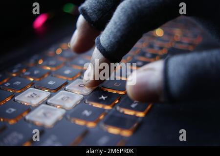 hacker hand stealing data from laptop top down  Stock Photo