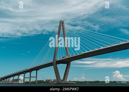 The Arthur Ravenel Jr. Bridge in Charleston, South Carolina on a partly sunny day with blue skies and traffic on the bridge. Stock Photo