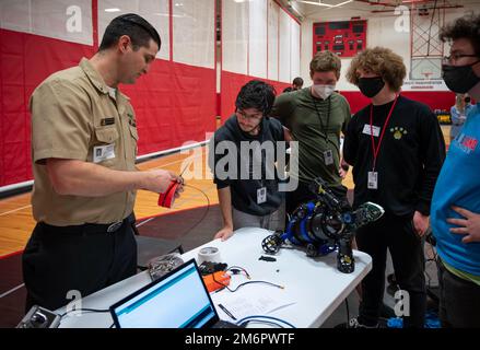 220504-N-WF272-1017 LANCASTER, Pa. (May 4, 2022) Electrician's Mate (Nuclear) 1st Class Hunter Timmons, left, assigned to Navy Talent Acquisition Group Philadelphia, helps J.P. McCaskey High School students resolve an issue with their submersible during the Sea, Air and Land Challenge held in Lancaster, Pennsylvania, May 4, 2022. The Sea Air and Land Challenge is an Office of Naval Research sponsored program, in which teams of high school students learn about the engineering process through the design and build of robotic systems. The systems are then used to compete in challenges relevant to Stock Photo