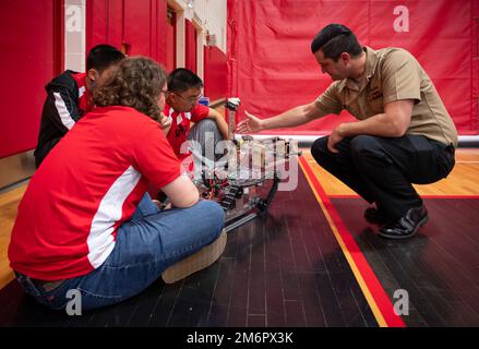 220504-N-WF272-1021 LANCASTER, Pa. (May 4, 2022) Electrician's Mate (Nuclear) 1st Class Hunter Timmons, right, assigned to Navy Talent Acquisition Group Philadelphia, learns about a land robot built by J.P. McCaskey High School students as part of the Sea, Air and Land Challenge held in Lancaster, Pennsylvania, May 4, 2022. The Sea Air and Land Challenge is an Office of Naval Research sponsored program, in which teams of high school students learn about the engineering process through the design and build of robotic systems. The systems are then used to compete in challenges relevant to the De Stock Photo