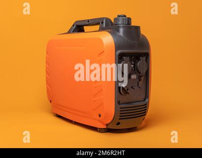 Inverter gasoline generator on an orange background. Stock Photo