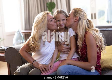 Caucasian woman with her daughter and mother sitting on a couch Stock Photo