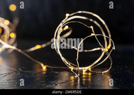 Fairy lights led garland coil, blurred, on a black background Stock Photo