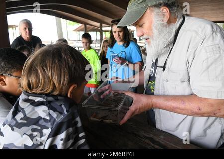 David Withers, a biologist from the Department of Environment and Conservation, shows Union Elementary STEAM students a small salamander habitat after teaching them the importance of hydropower to the local wildlife at the Old Hickory Lake picnic area in Hendersonville, Tennessee on May 4, 2022. Stock Photo