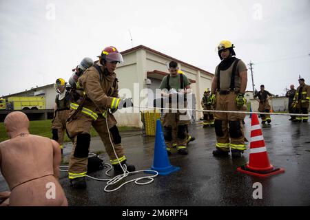 U.S. service members with Headquarters and Headquarters Squadron, Marine Corps Air Station Futenma, Marine Corps Installations Pacific, monitor a rope pulling event during a firefighter Physical Ability Test on Marine Corps Air Station Futenma, Okinawa, Japan, May 4, 2022. The firefighters’ Physical Ability Test is a tool used to measure how effective a Marine is while performing multiple tasks over a set period. The test consists of 10 tasks that evaluate cardiovascular and strength performance. Stock Photo