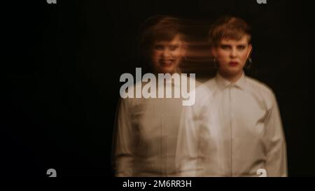 crazy psychopathic girl with mental disorders in a straitjacket on a dark background Stock Photo