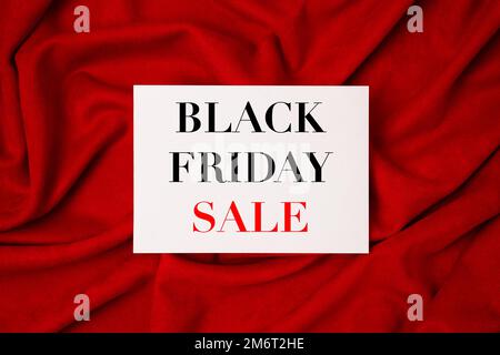 Black Friday sale shopping text on tablet screen on red fabric background.Sale promotion poster. Discount, sale season. Stock Photo