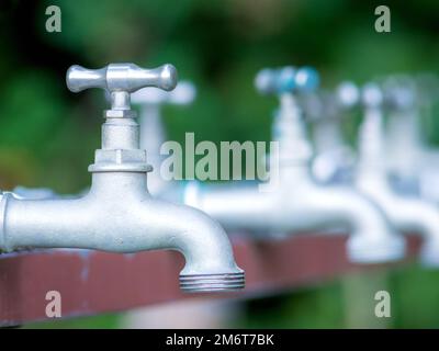 Brass water tap in nature background. Stock Photo