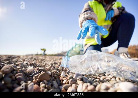 Group of cleanup volunteers cleaning up waste in nature and holding a garbage bag trash Stock Photo