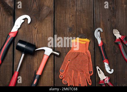 A set of construction tools on a brown wooden background, top view. Stock Photo