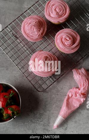 upper view of vanilla muffins with buttercream frosting on top, grey marble table  Stock Photo