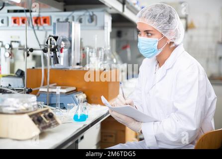 Portrait of young woman scientist taking notes in laboratory Stock Photo