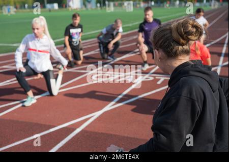 Female coach and group of children conducts a training session Stock Photo