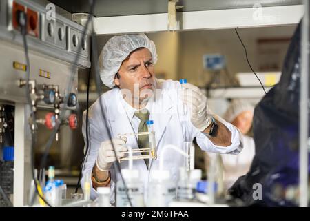 Focused man technician working in research laboratory Stock Photo