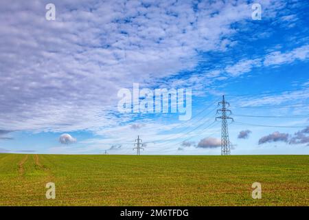 High voltage power lines against a blue sky Stock Photo