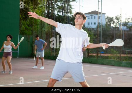 Young man playing Basque pelota on outdoor pelota court Stock Photo