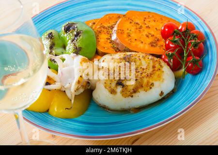 Sepia fried on a grill with Bulgarian pepper and boiled batat is tasty dish Stock Photo