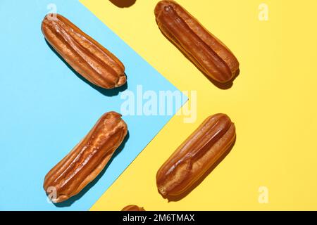 Composition with sweet eclairs on color background Stock Photo
