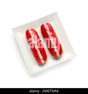 Plate with delicious glazed eclairs isolated on white background Stock Photo