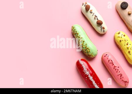 Many delicious glazed eclairs on pink background Stock Photo