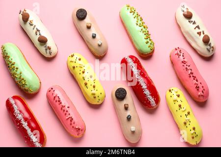 Many delicious glazed eclairs on pink background Stock Photo