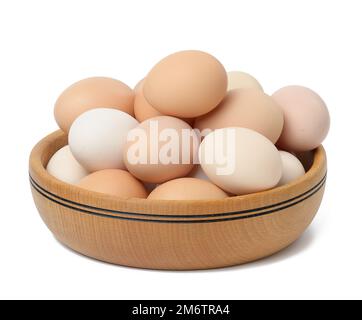 Raw brown and white chicken eggs in a wooden plate Stock Photo