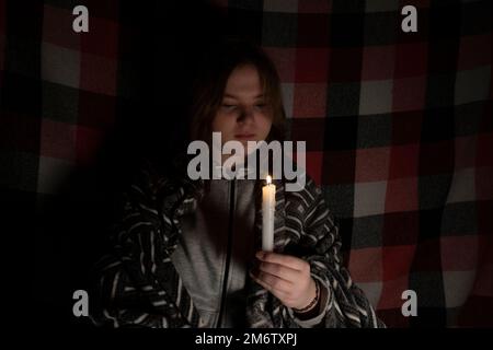 Blackout. Energy crisis. Power outage concept. Girl holds in her hands two  burning candles with a yellow-blue ribbon (the national symbol of Ukraine  Stock Photo - Alamy