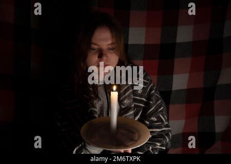 https://l450v.alamy.com/450v/2m6txpk/girl-with-a-burning-candle-in-a-dark-room-blackout-energy-crisis-destruction-of-infrastructure-power-outage-concept-2m6txpk.jpg