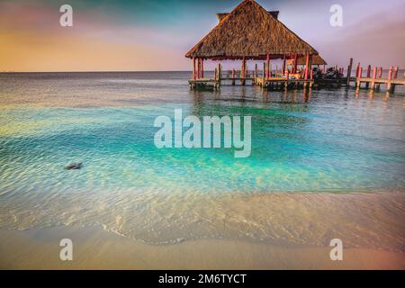 Tropical paradise, sand beach in caribbean with palapa and pier, Cancun, Mexico Stock Photo