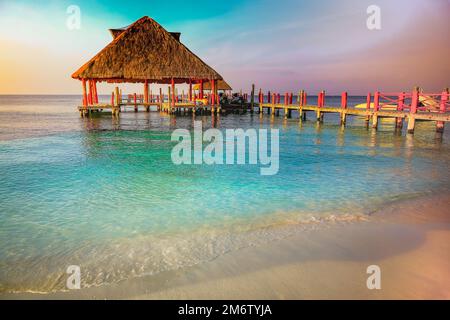 Tropical paradise, sand beach in caribbean with palapa and pier, Cancun, Mexico Stock Photo