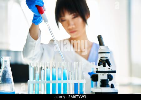 Asian scientist working in big modern laboratory doing some research Stock Photo