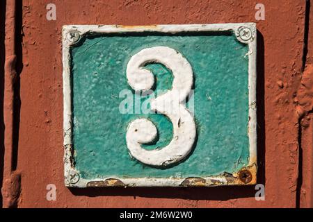 Old retro weathered cast iron plate with number 3 closeup Stock Photo