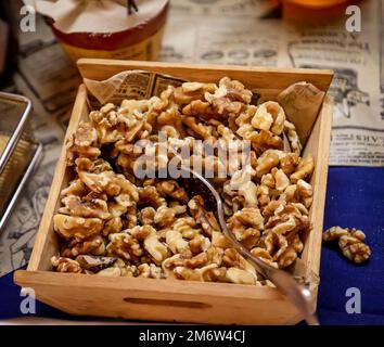 Lots of walnut kernels in a wooden box on a buffet. Stock Photo